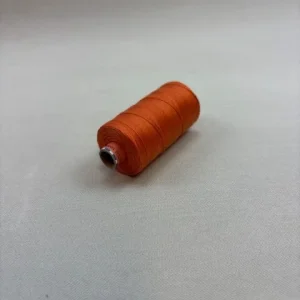 Kleine Spule mit orangefarbenem Saba 30-Kapellfaden